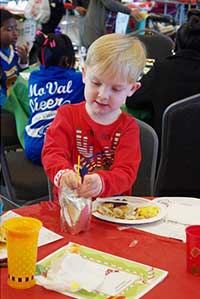 Photo of child enjoying breakfast with Santa